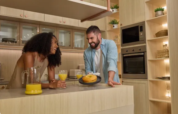 Casal em cozinha planejada com ilha central